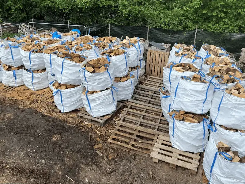 A pile of bulk bags filled to the brim with firewood