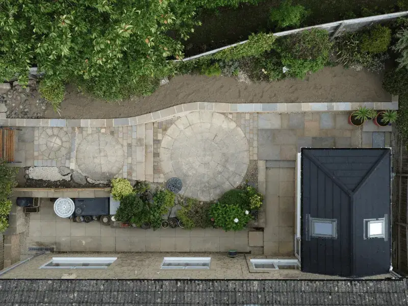 Aerial photograph of a garden with a stone patio and a raised stone bed.